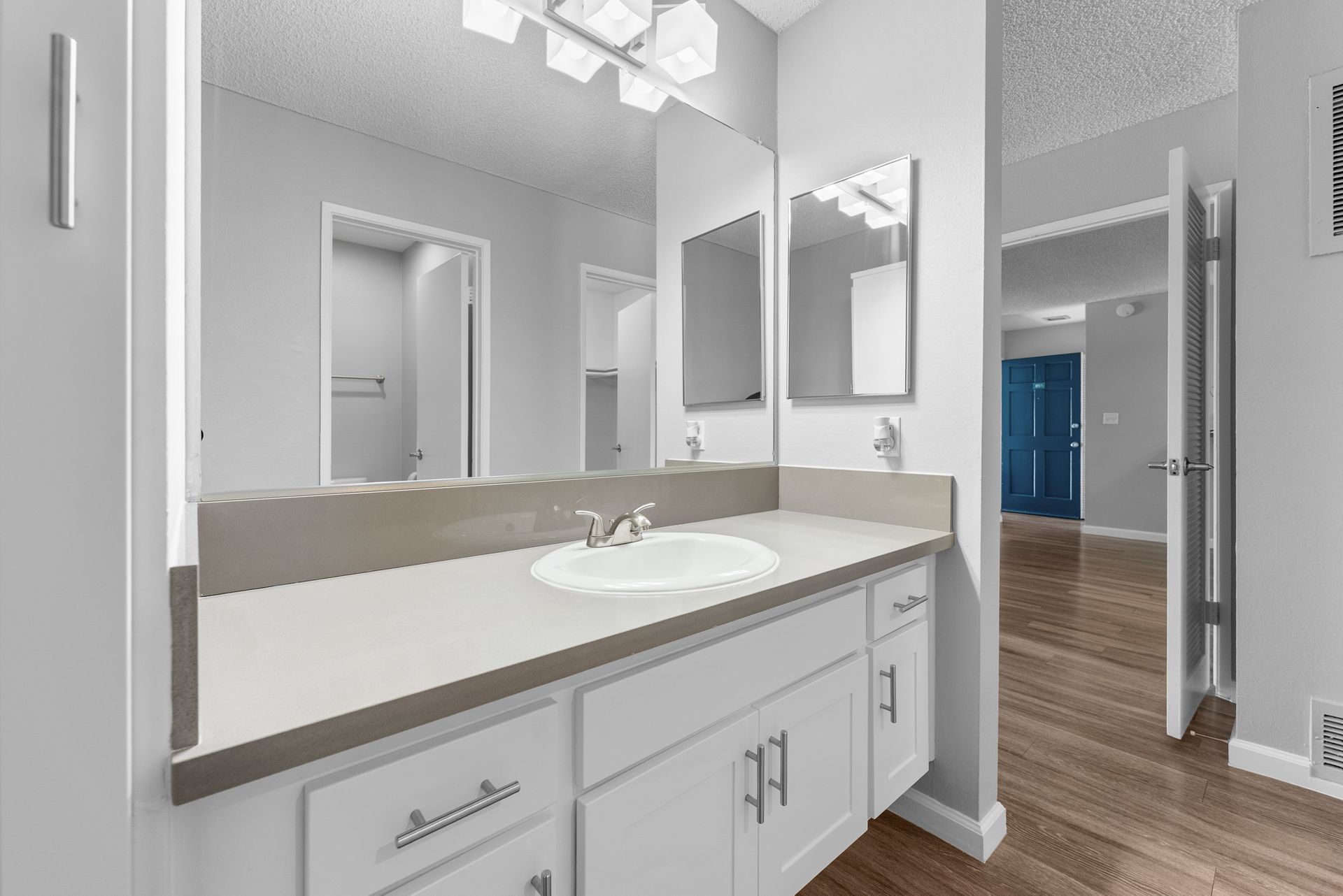 A bathroom with a sink and two mirrors.
