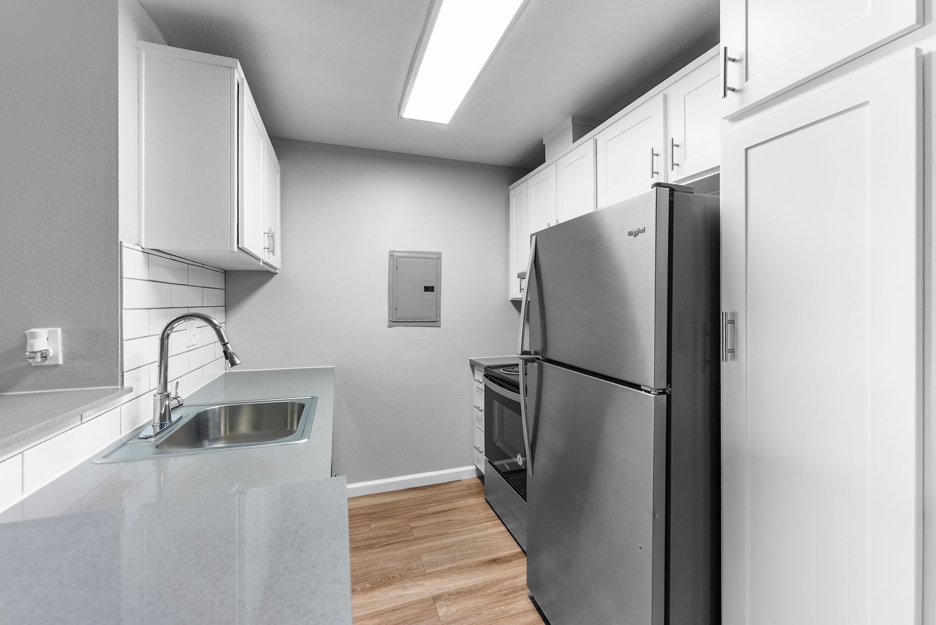 A kitchen with stainless steel appliances and white cabinets