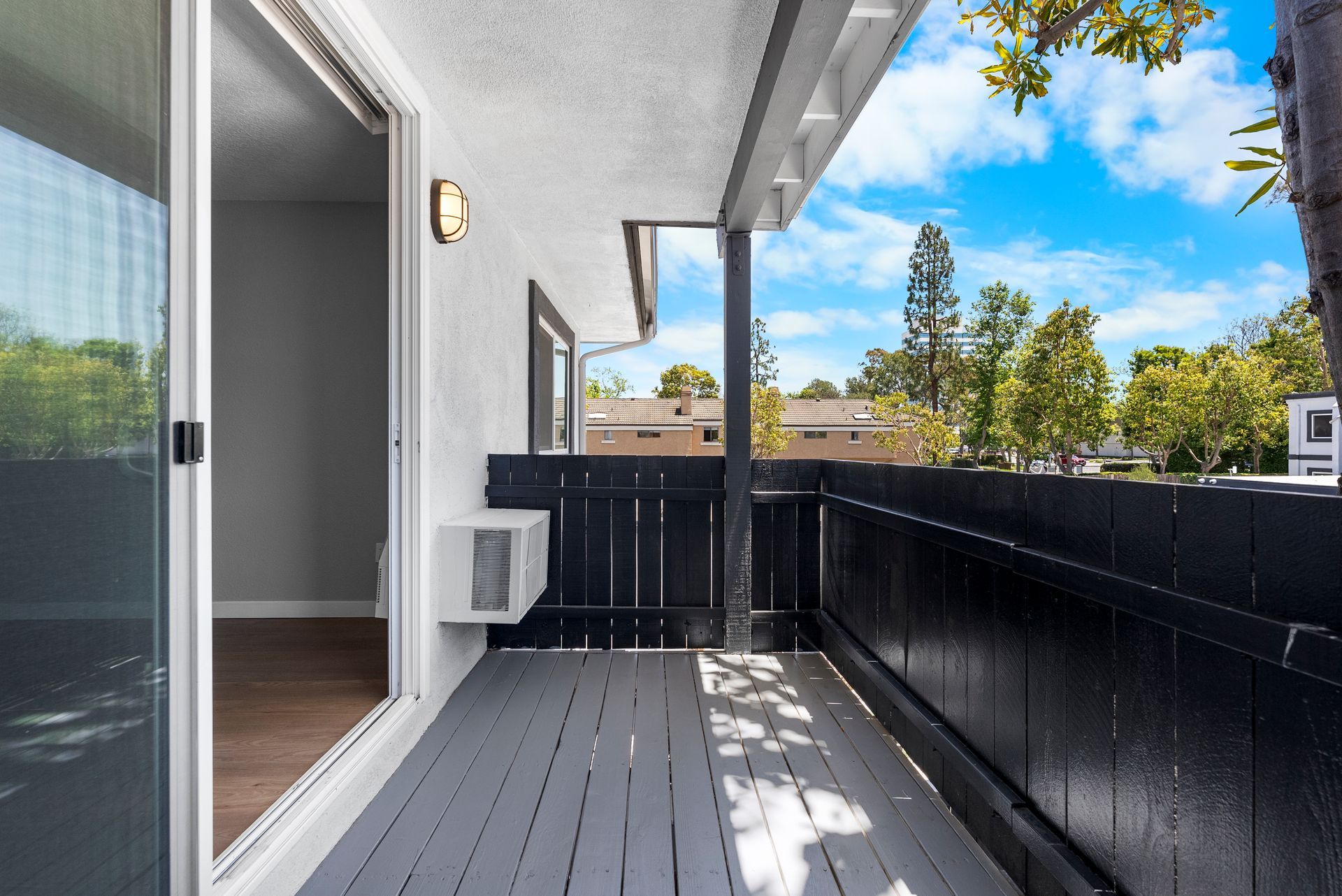 A balcony with a black fence and a sliding glass door