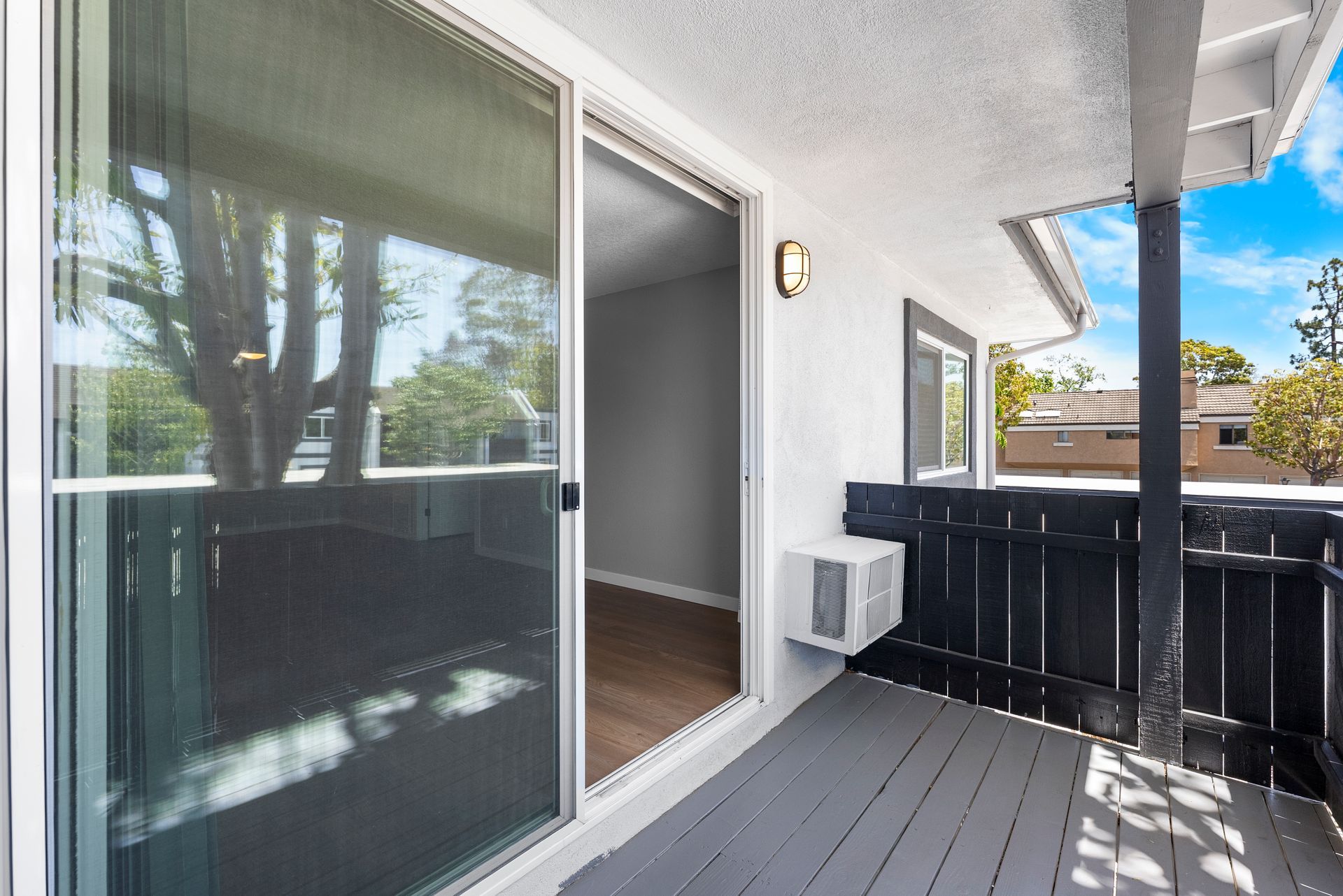 A balcony with a sliding glass door and a window