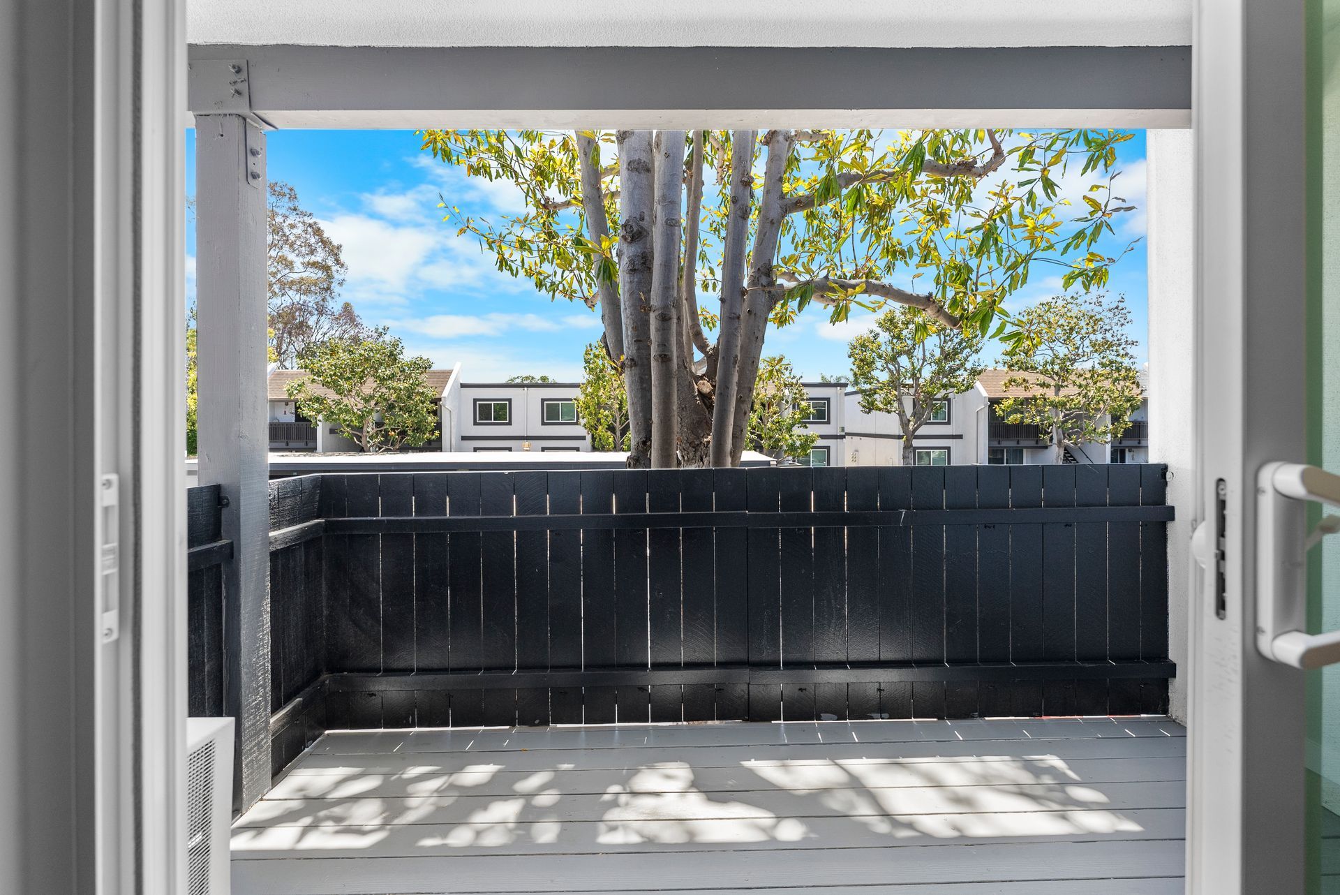 A view of a balcony through a sliding glass door.