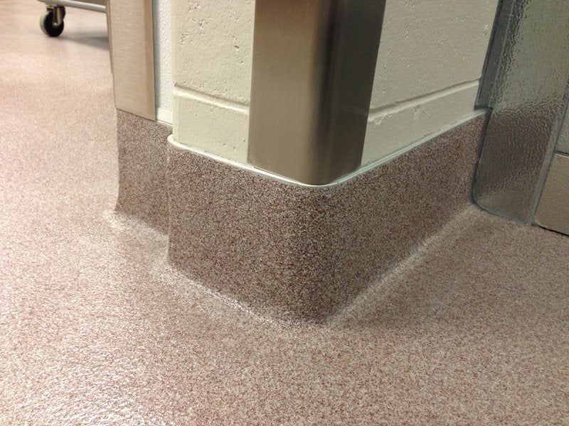 Hospital hallway corner with protective wall base and speckled flooring