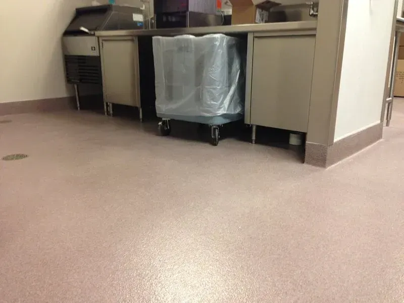 Empty hospital room with beige floor and covered equipment under a counter