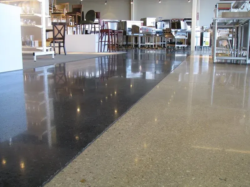 Empty café interior with shiny black and beige floor, tables, and chairs in the background