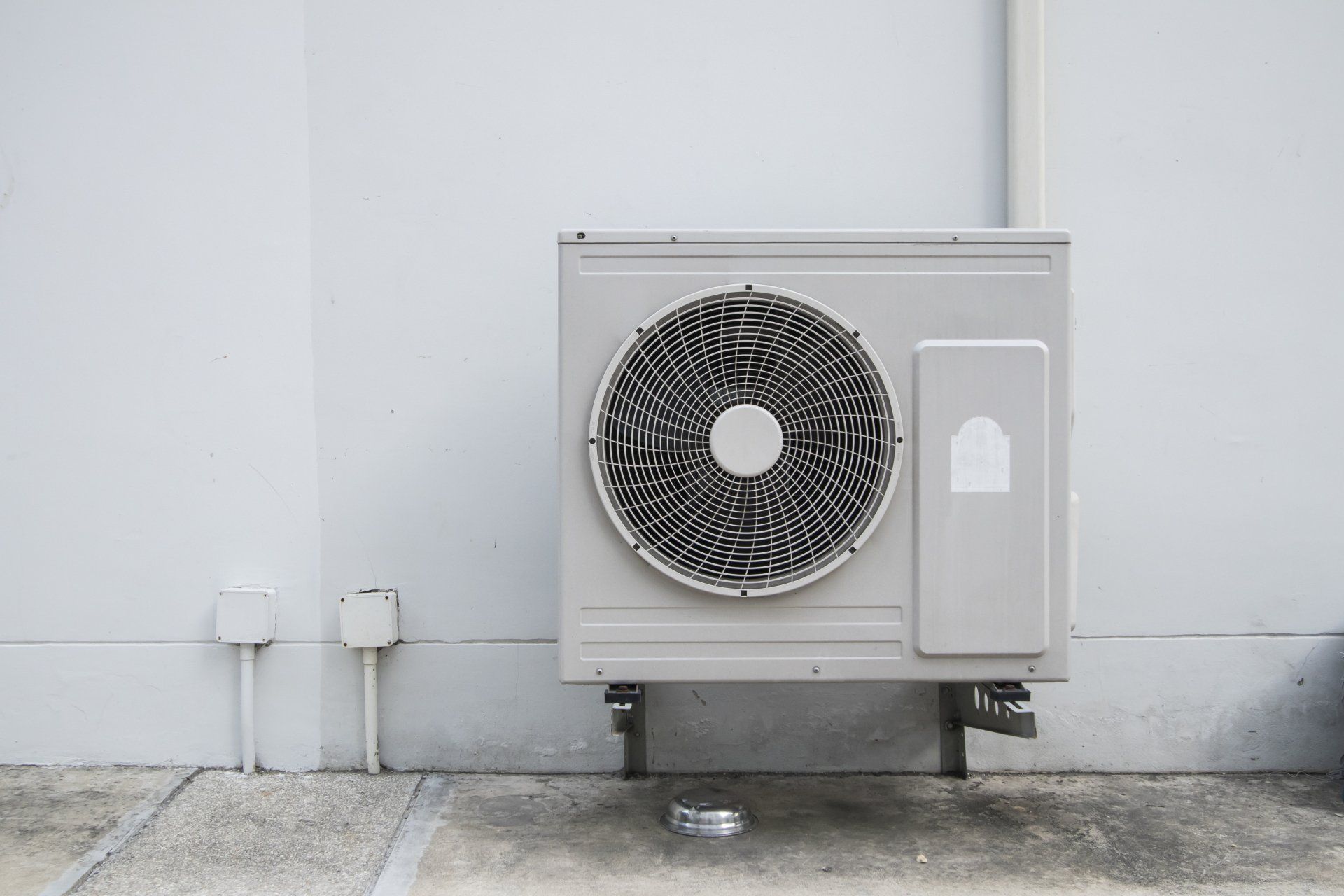 Un climatiseur blanc est posé sur le côté d'un bâtiment.