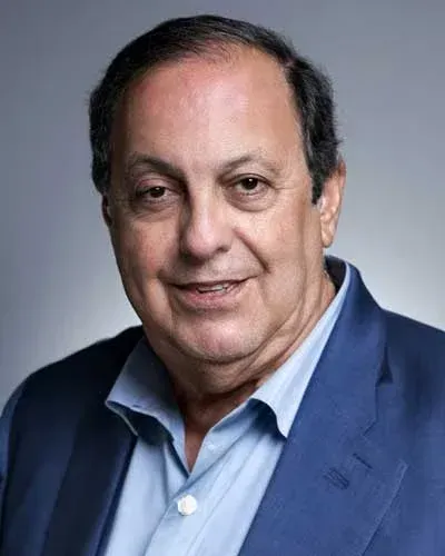 Studio portrait of a man in a blue blazer and light blue shirt against a gray background Studio portrait of a man in a blue blazer and light blue shirt against a gray background