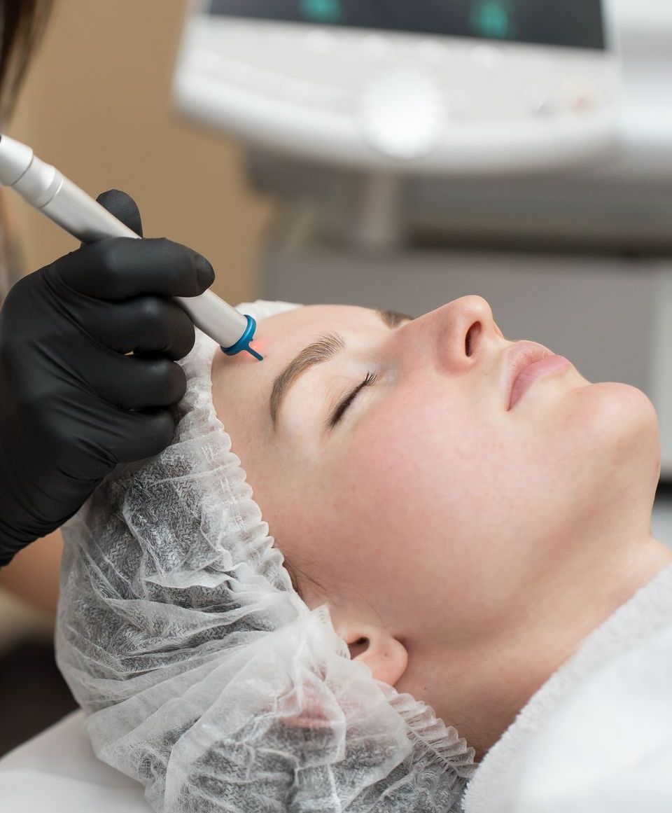 woman receiving laser hair removal treatment on  face