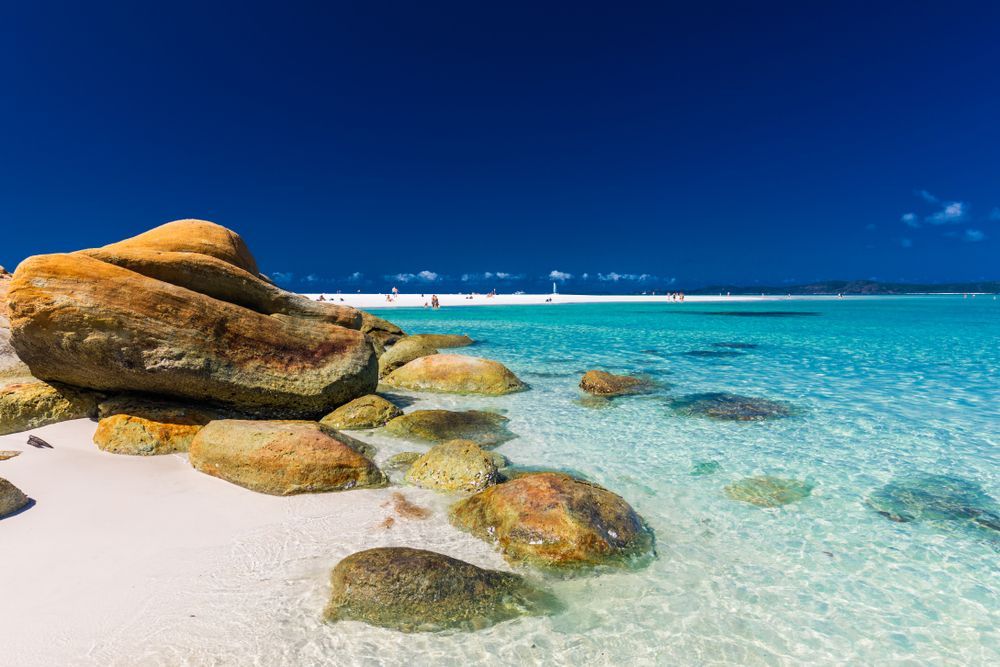 A Large Rock Is Sitting On The Shore Of A Tropical Beach — Brian Martin's Sheet Metal In Whitsundays, QLD