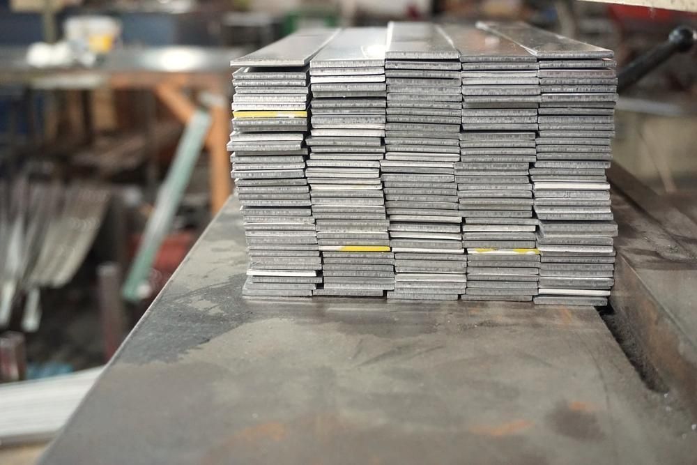 A Stack Of Metal Bars Sitting On Top Of Each Other On A Table — Brian Martin's Sheet Metal In Whitsundays, QLD