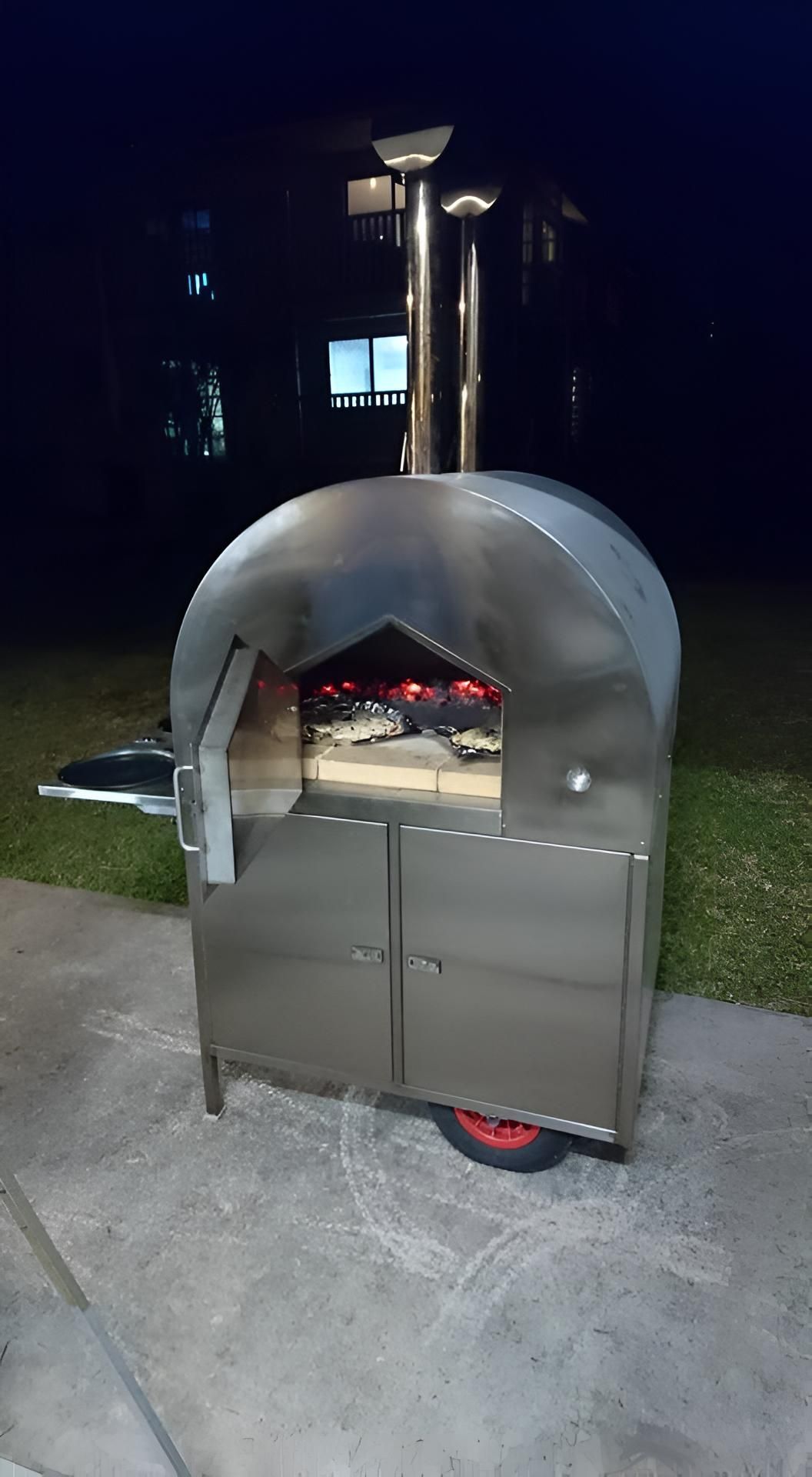 A Stainless Steel Pizza Oven Is Sitting On A Sidewalk At Night — Brian Martin's Sheet Metal In Moranbah, QLD