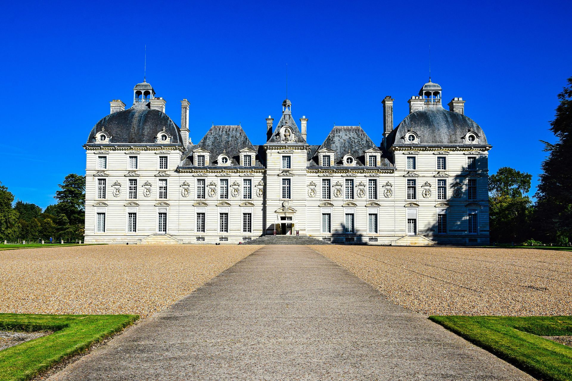 Majestic château in the Loire Valley with a symmetrical façade, a long entrance path, and beautifully manicured gardens
