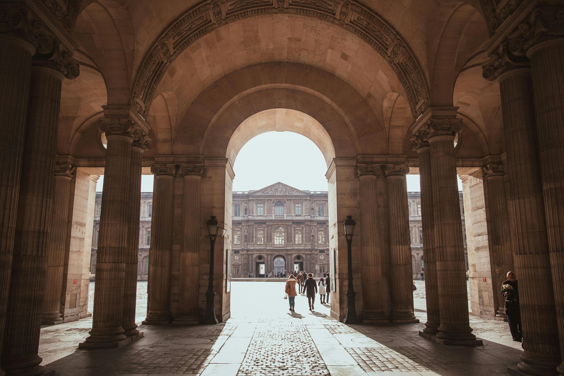 Elegant archways leading to the courtyard of the Louvre Museum in Paris, France