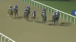 Horse race with nine jockeys riding on a dirt track near the white rail.