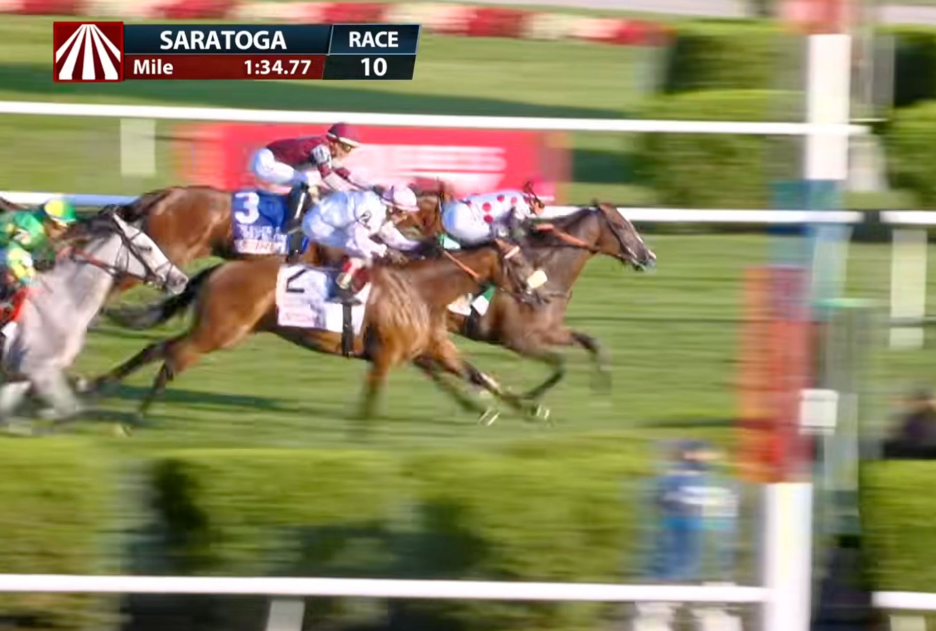 Horse race at Saratoga, with jockeys racing closely on a turf track.