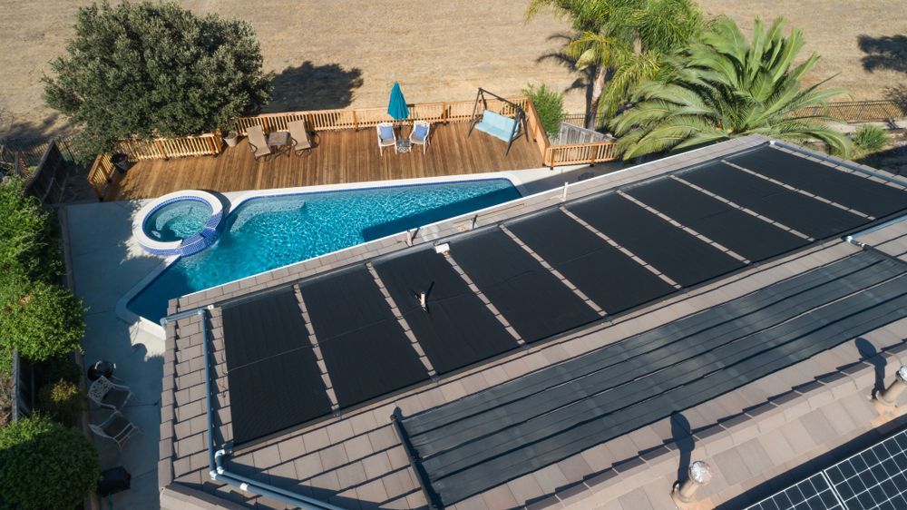 An Aerial View of a House With a Swimming Pool and Solar Panels on the Roof — Solar Services in Erina, NSW