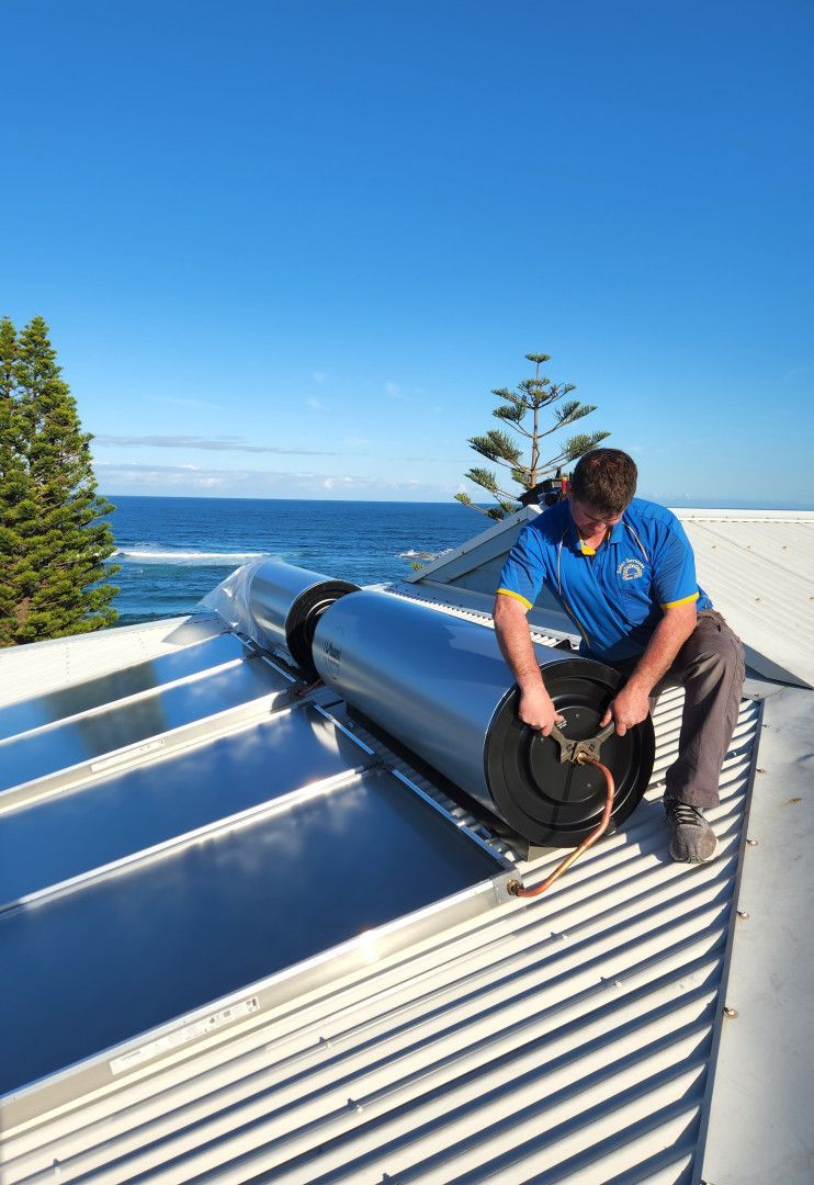 Man Installing a Solar Hot Water System on a Rooftop — Solar Services in Erina, NSW