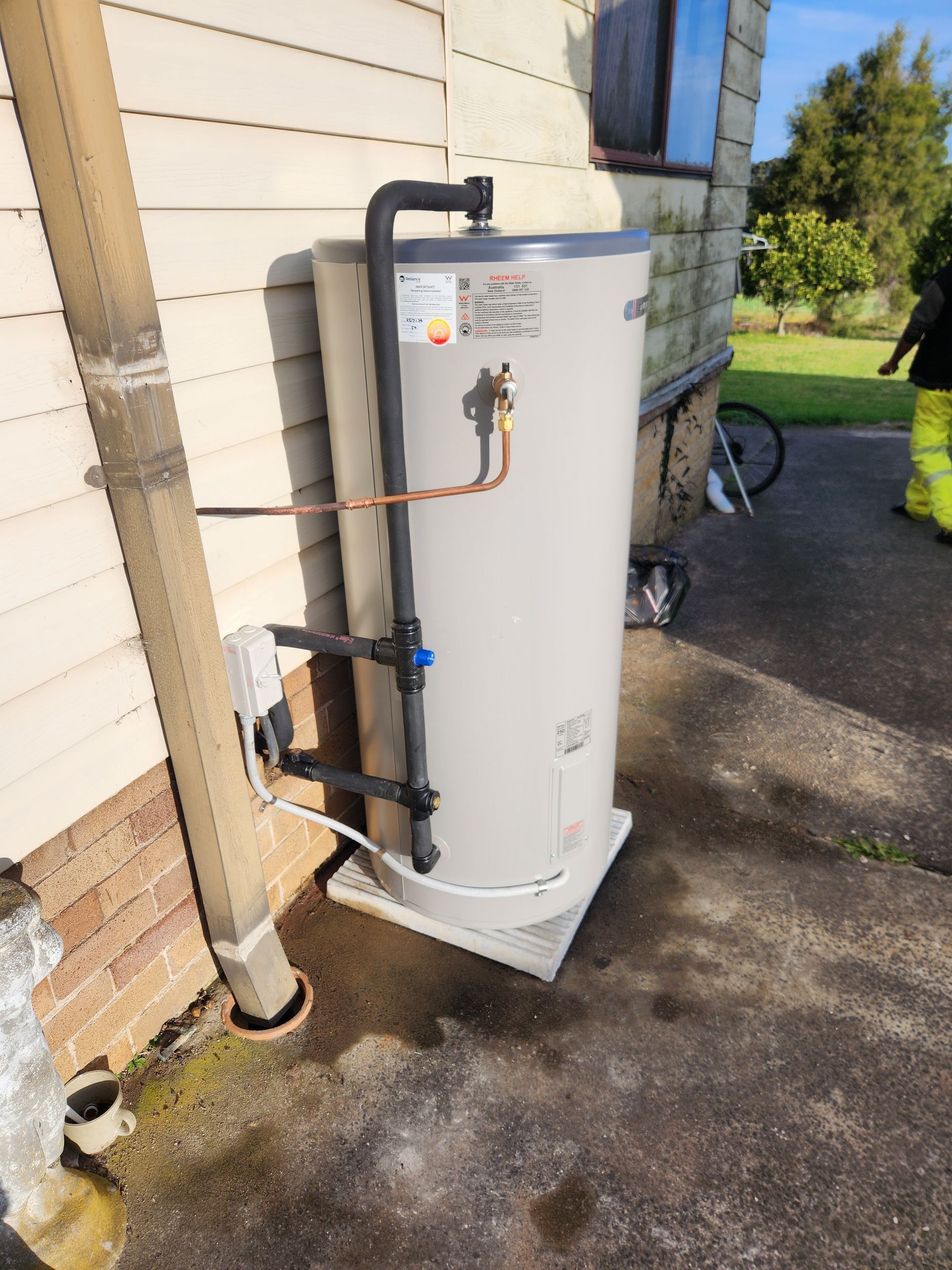 A Water Heater is Attached to the Side of a Building — Solar Services in Erina, NSW