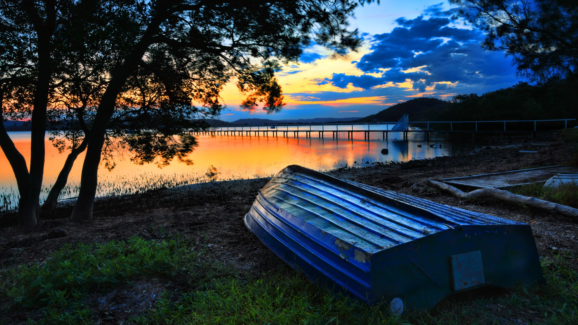 There is a Dock in the Middle of a Lake at Sunset — Solar Services in Kincumber, NSW