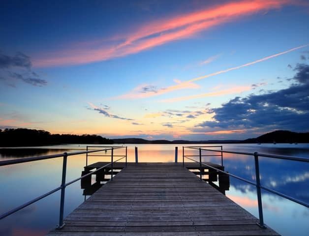 A Dock Overlooking a Body of Water at Sunset — Solar Services in Kincumber, NSW
