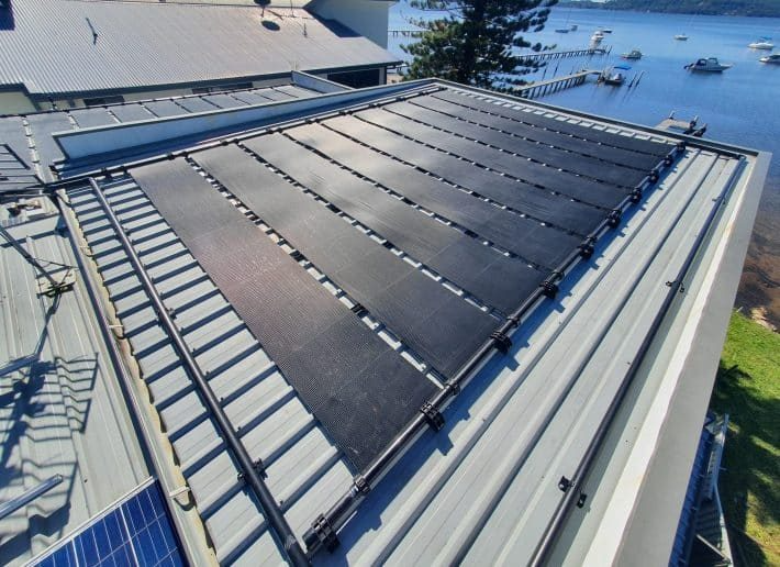 A Row of Solar Panels on a Roof With the Sun Shining Through Them — Solar Services in Erina, NSW