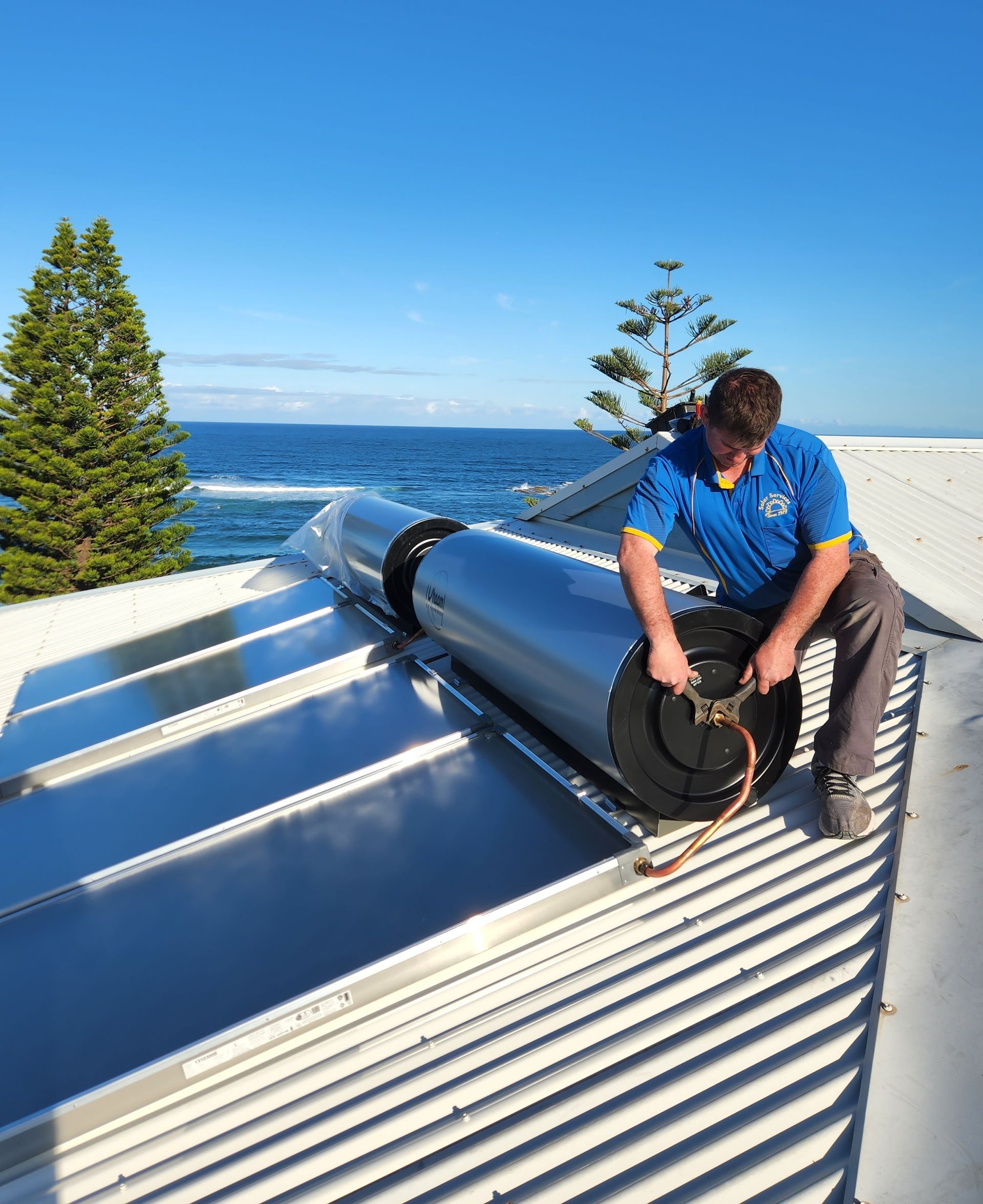 A Solar Water Heater is on the Roof of a House Overlooking the Ocean — Solar Services in Erina, NSW