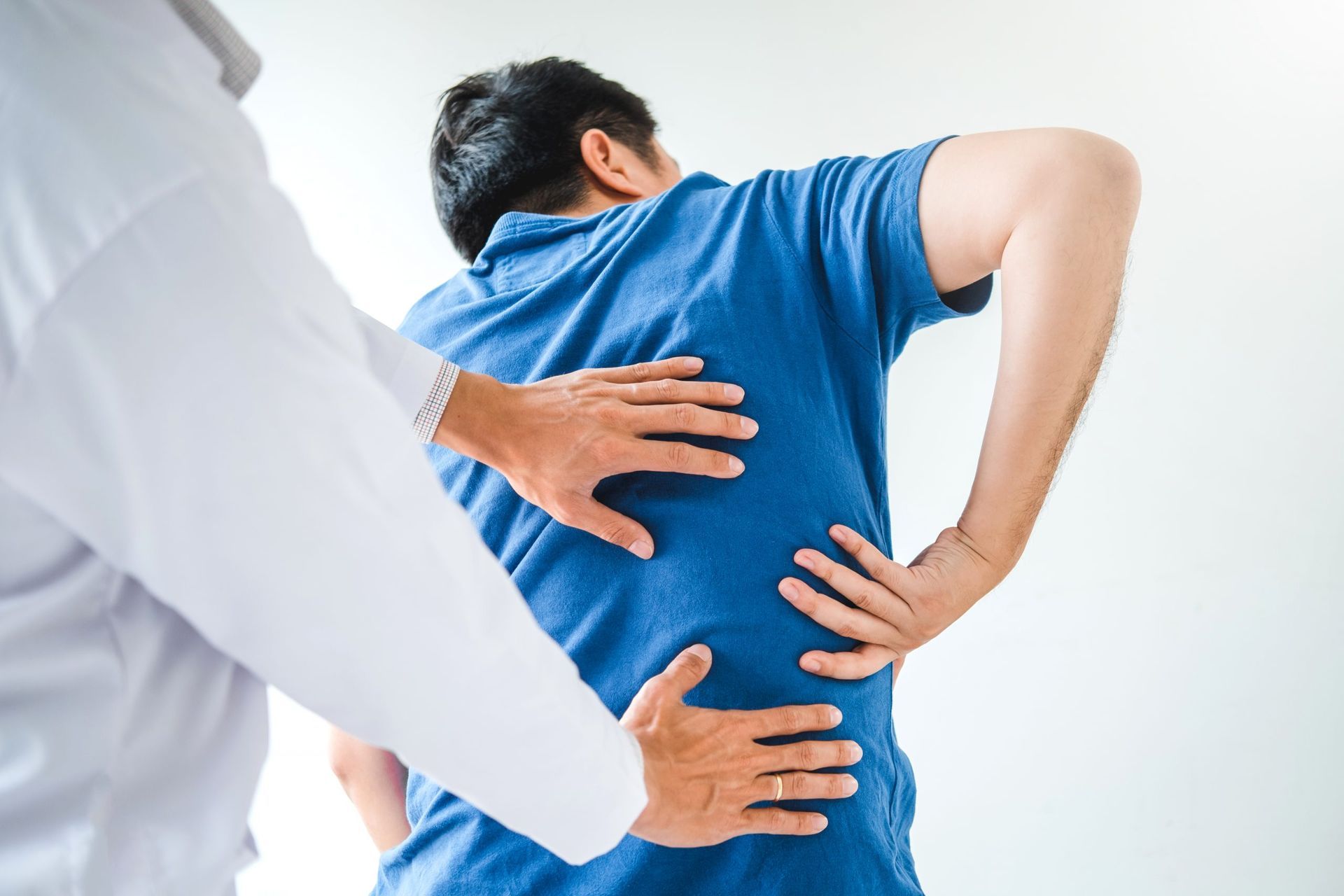 Un uomo si sta facendo visitare la schiena da un medico.