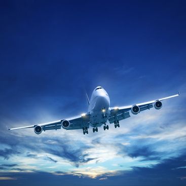 Airplane approaching for landing against a blue sky with clouds