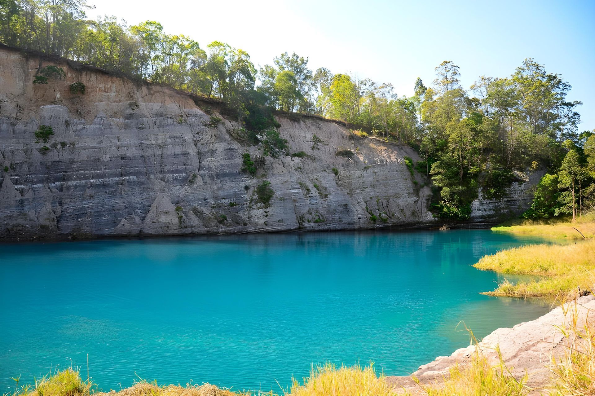 Azure-blue Lake in a Quarry, Surrounded by Layered Rock Cliffs and Green Trees — Hasti Skips in Lismore, NSW