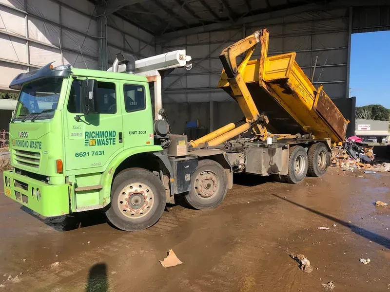 Green Waste Removal Truck With Raised Container at a Facility — Hasti Skips in Bangalow, NSW