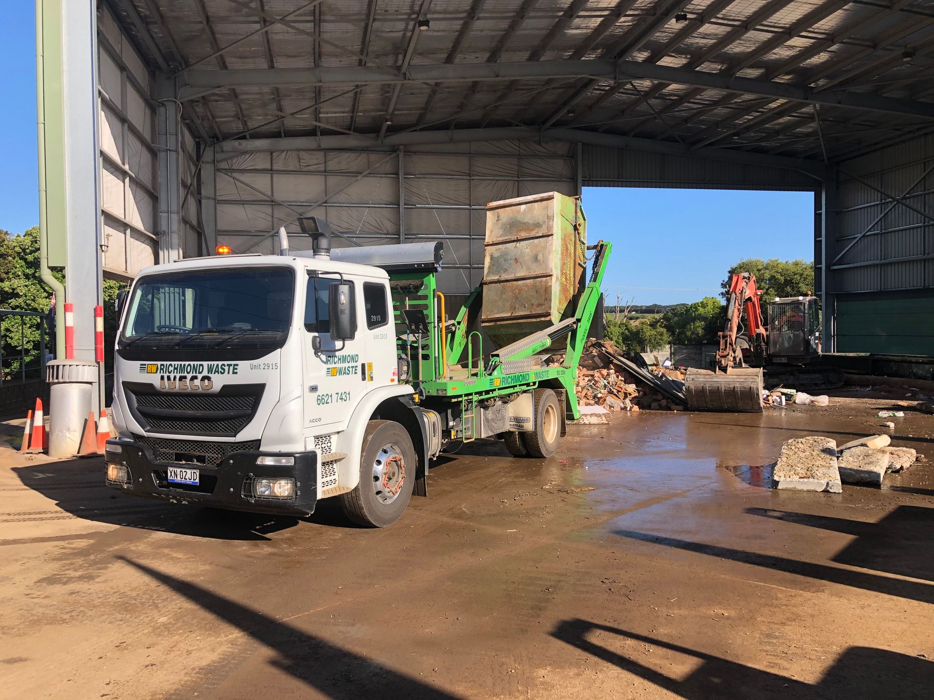 A large truck is tipping a container of rubbish into a dumping ground — Hasti Skips in Bangalow, NSW