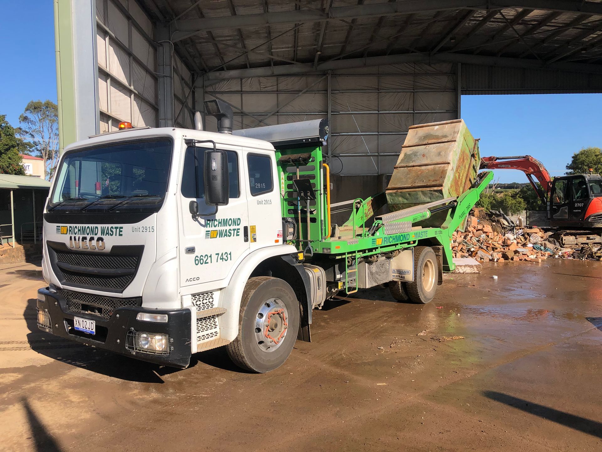 A large Richmond Waste Truck is parked in a rubbish dumping area — Hasti Skips in Byron Bay, NSW