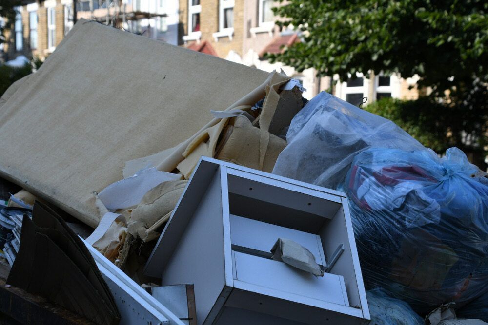 Pile of Discarded Furniture and Trash on a Street, Including a Cabinet, Mattress, and Bags — Hasti Skips in Bangalow, NSW