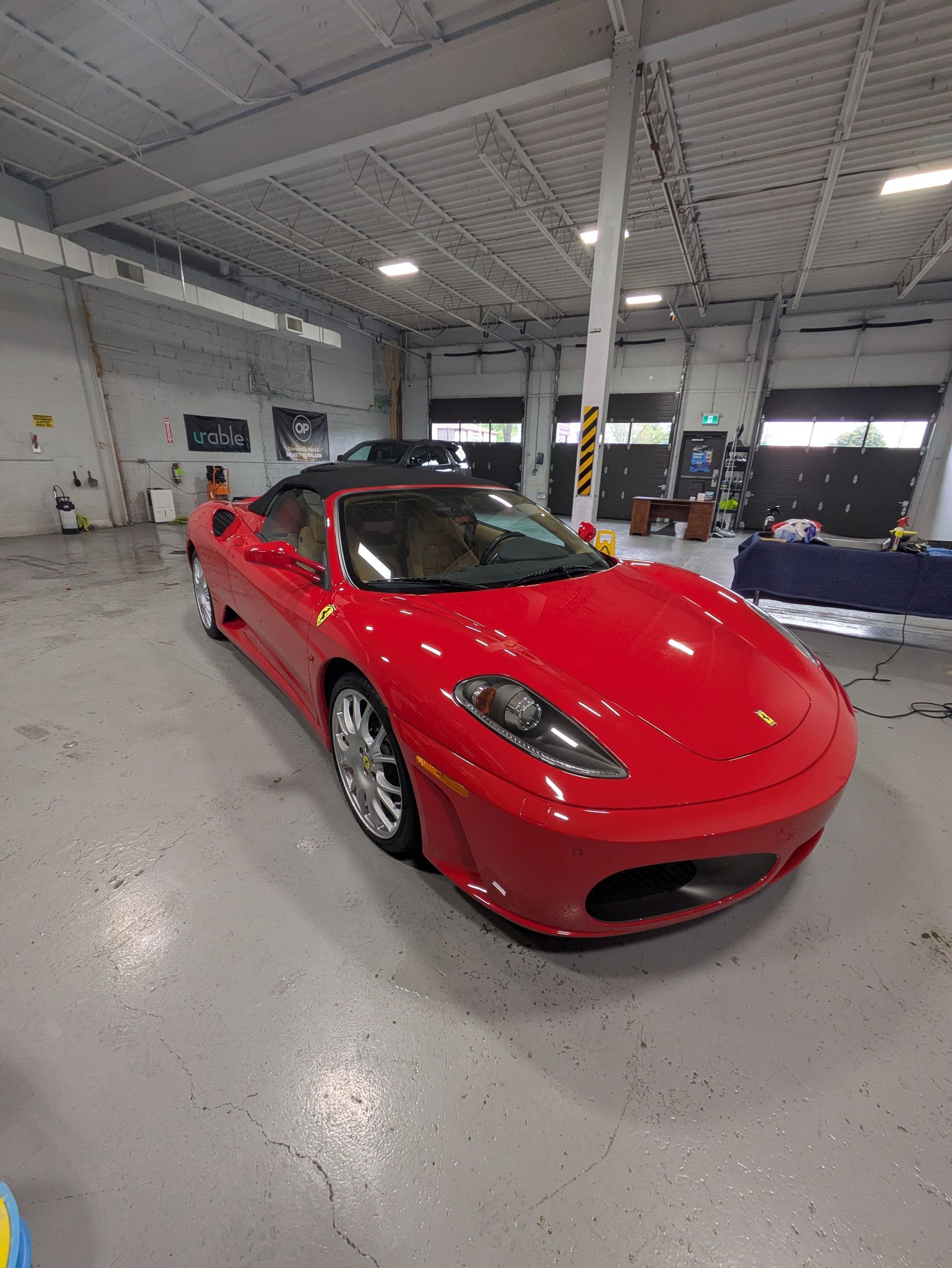 Red Ferrari convertible in a garage.