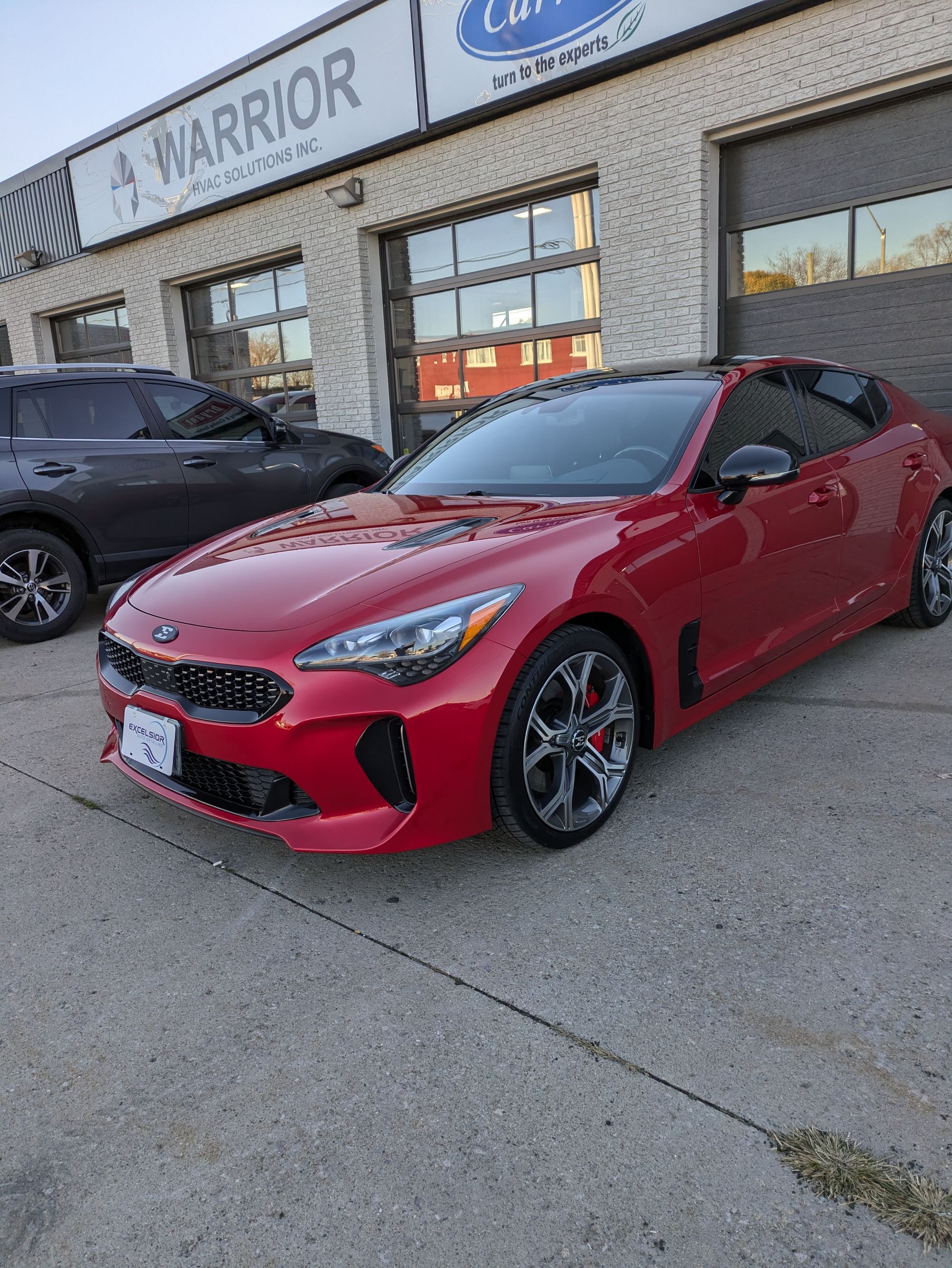 A red car is parked in front of a building.