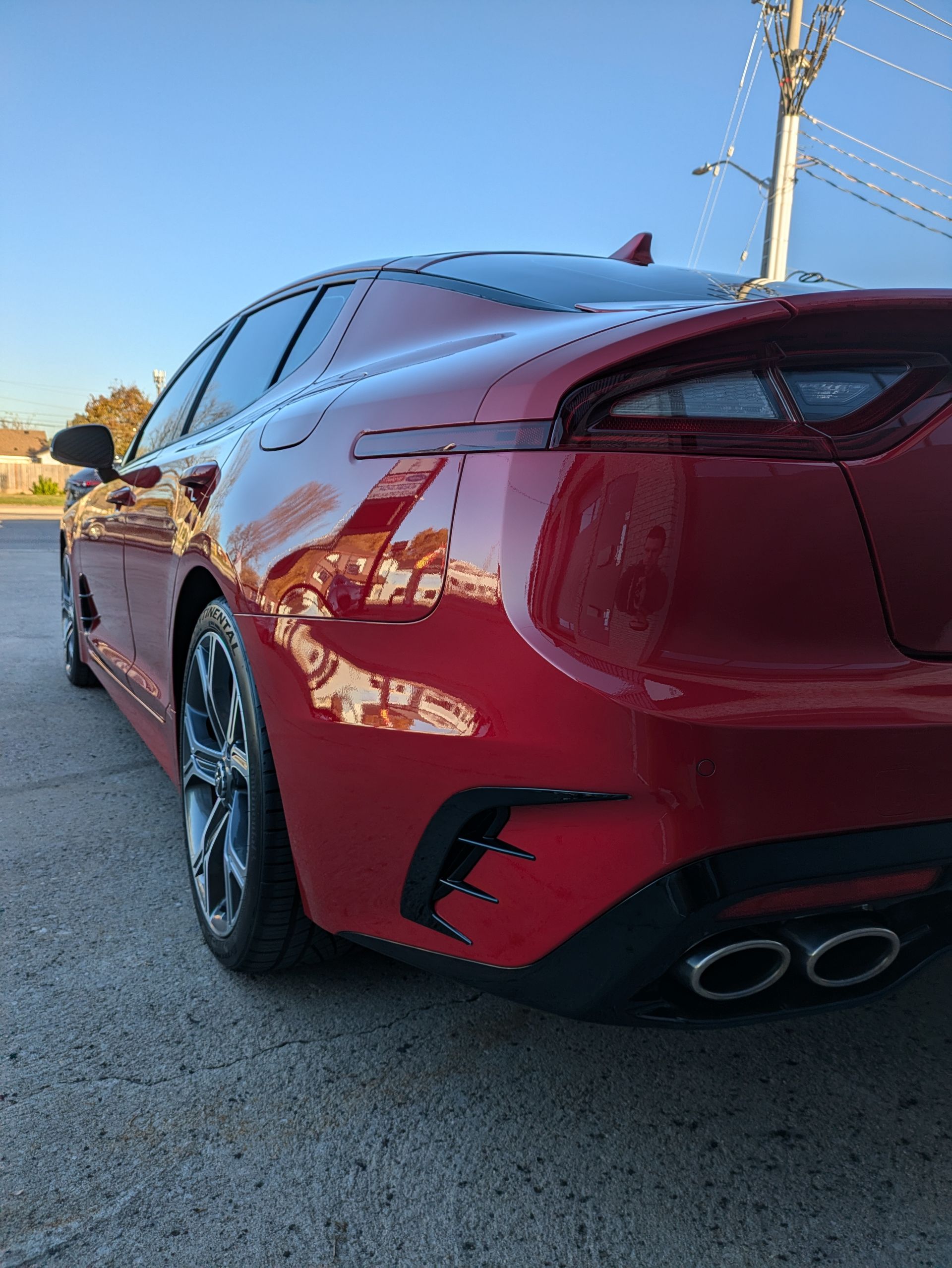 A red car is parked on the side of the road.