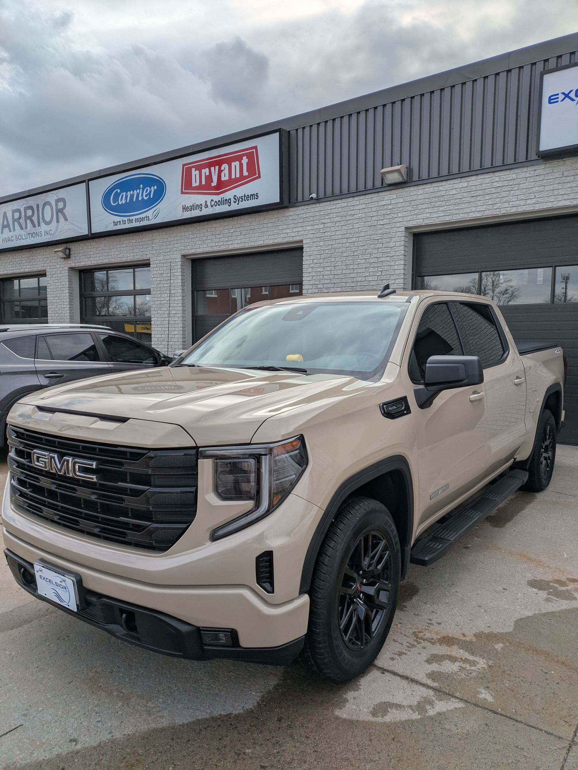 A gmc truck is parked in front of a building.