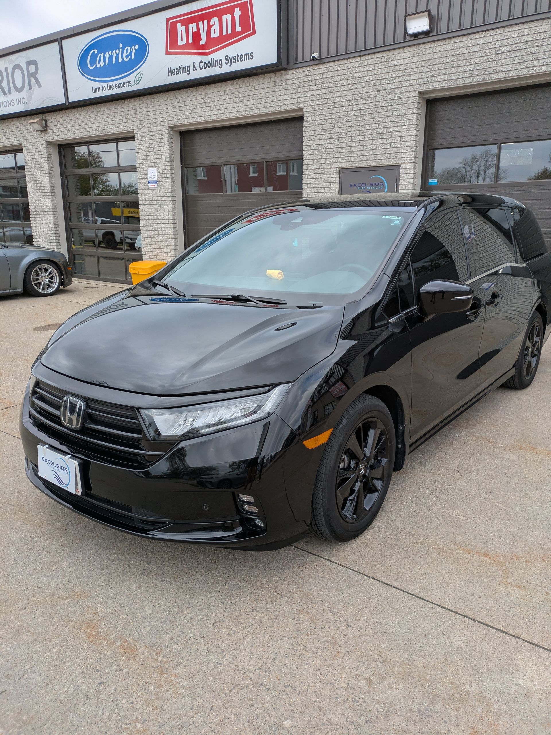 A black honda civic is parked in front of a building.
