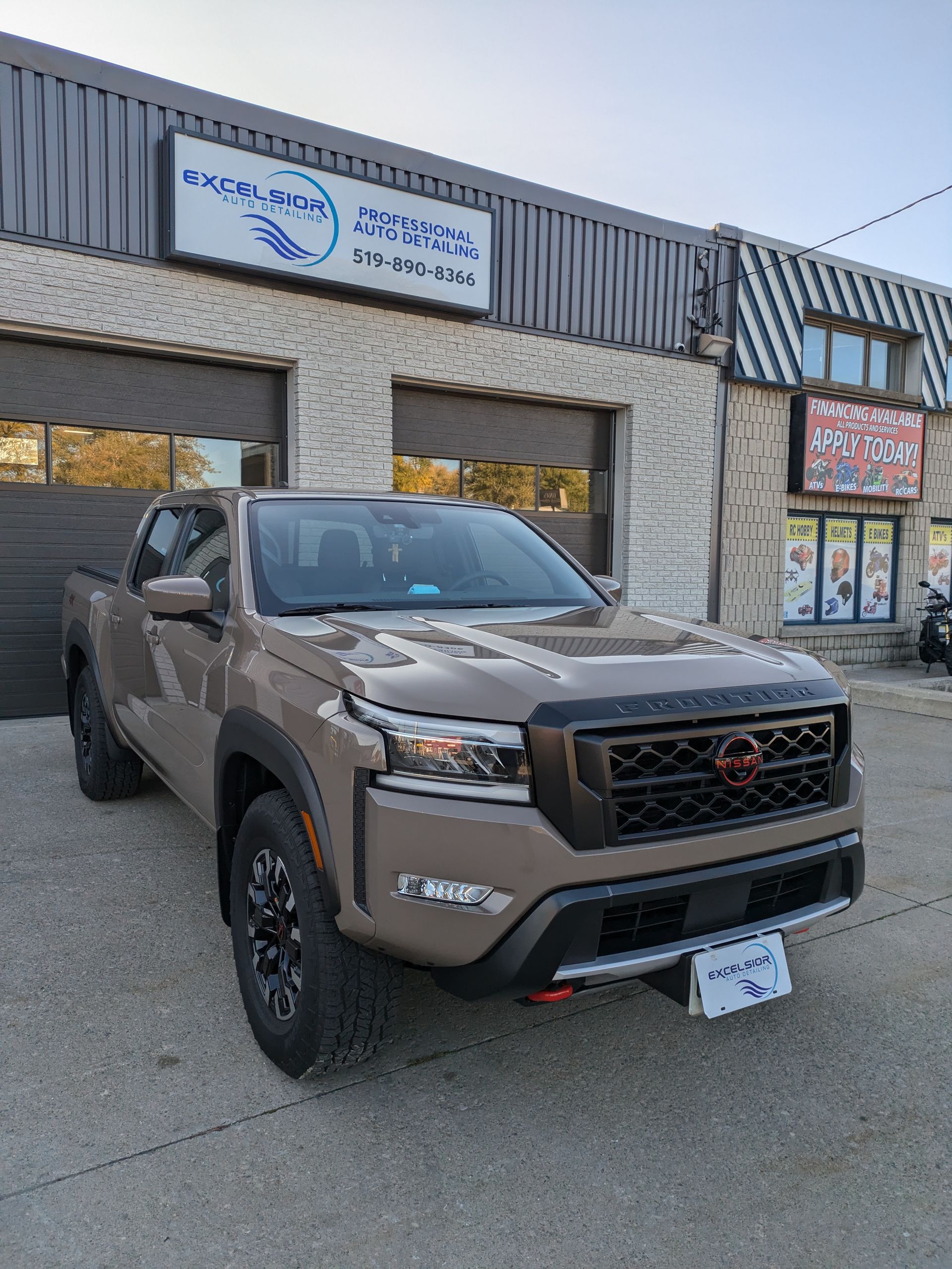 A pickup truck is parked in front of a building.