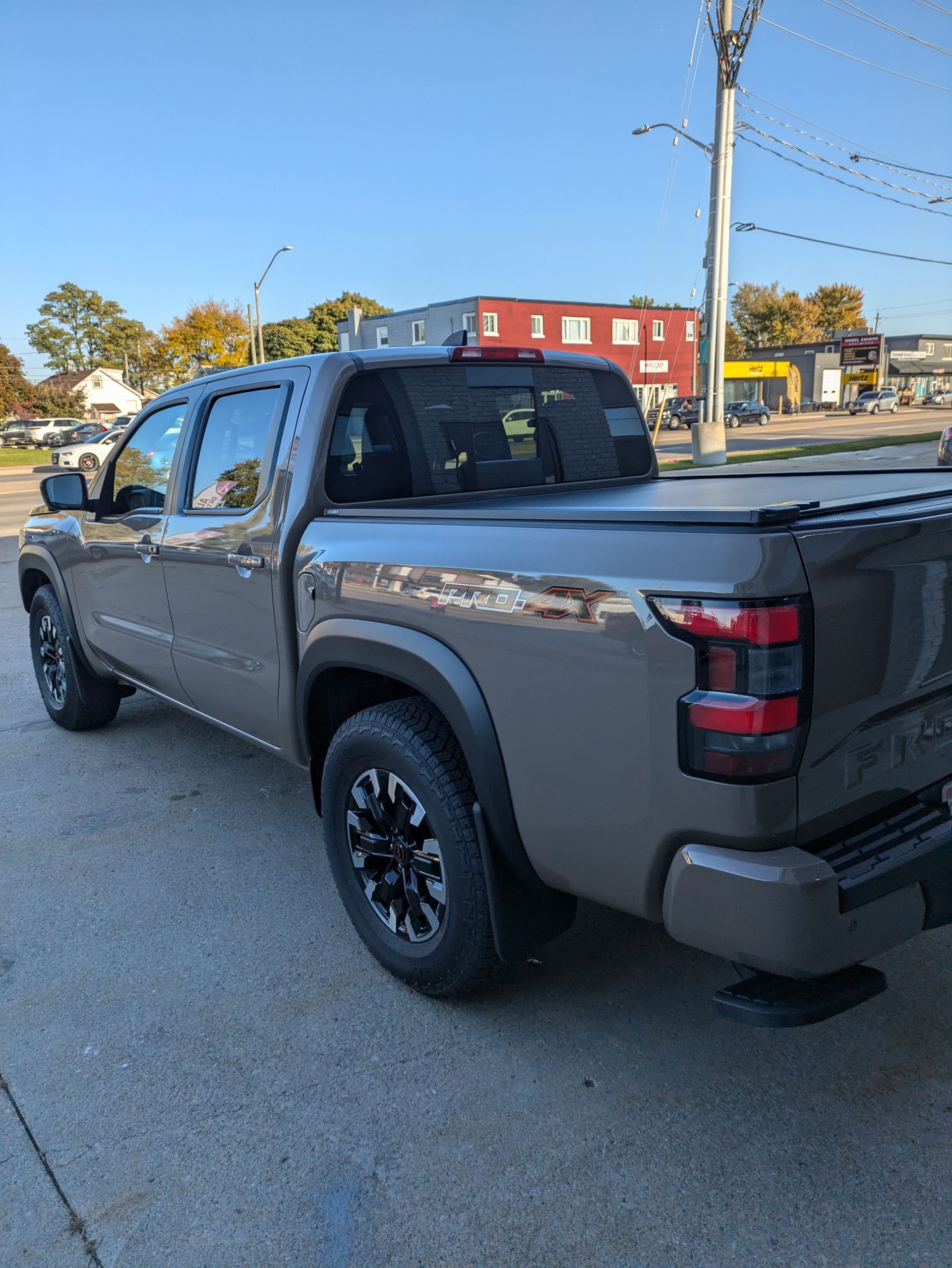 A nissan frontier truck is parked on the side of the road.