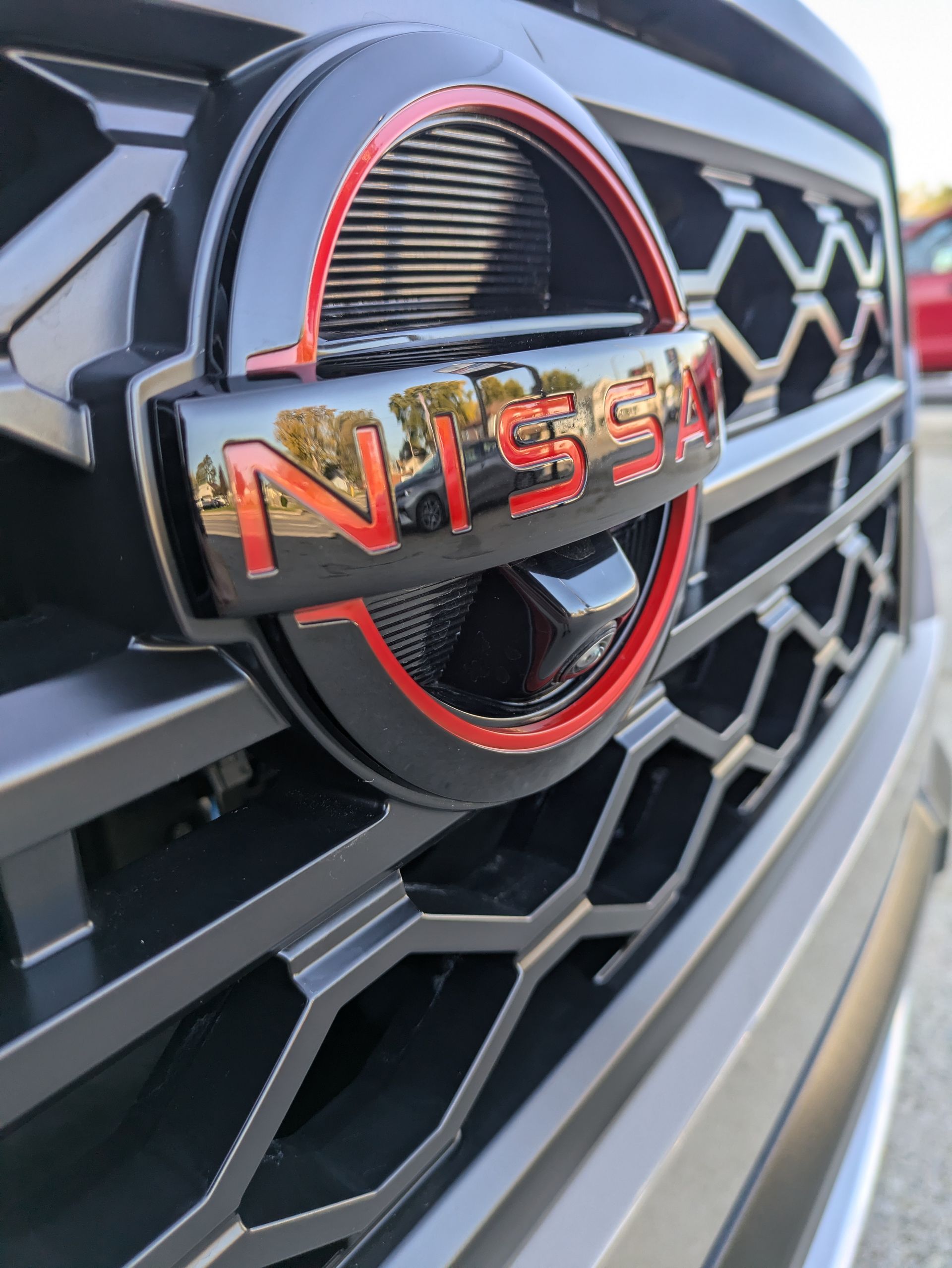A close up of a nissan logo on the front of a car