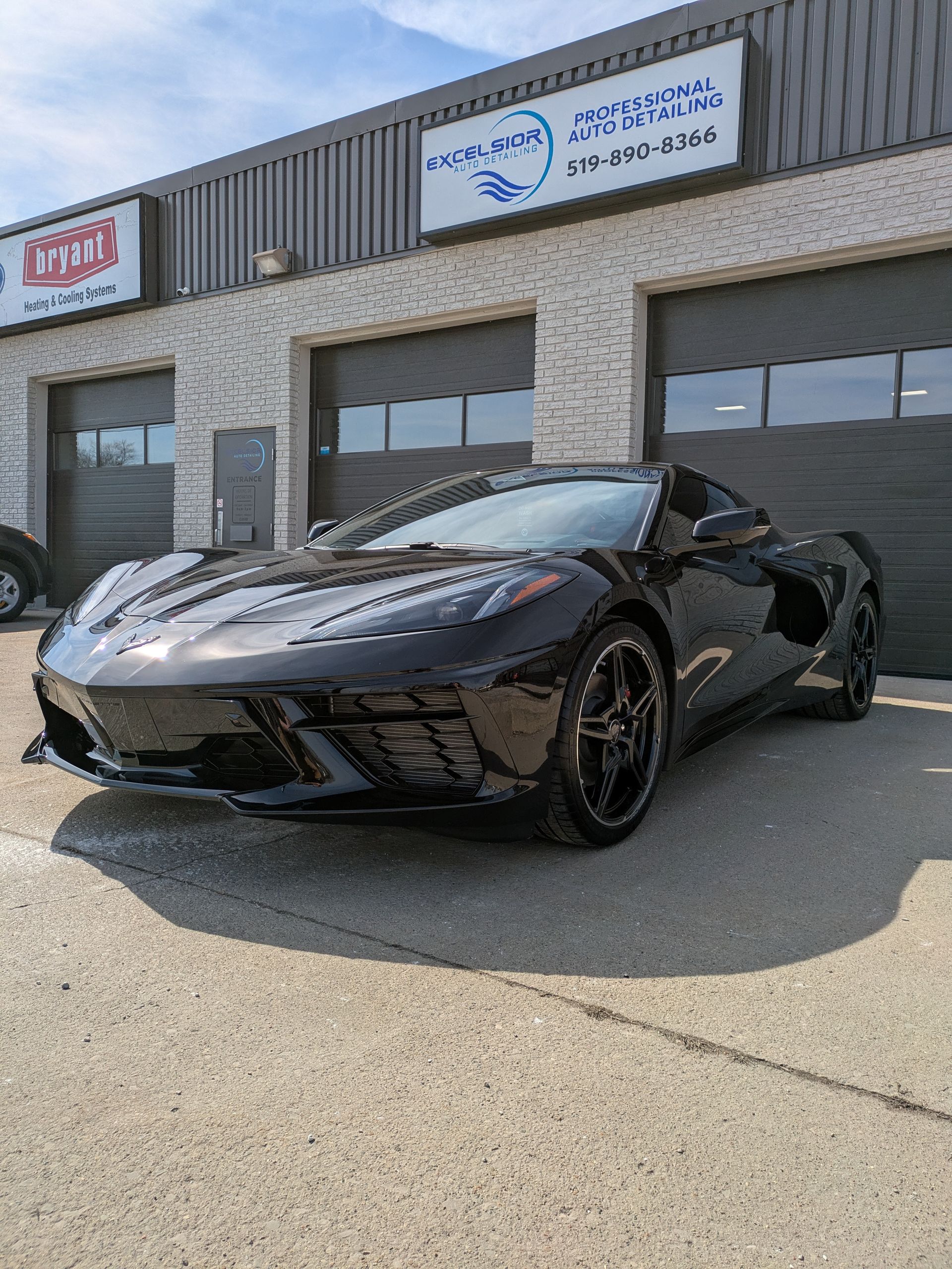 A black sports car is parked in front of a building.