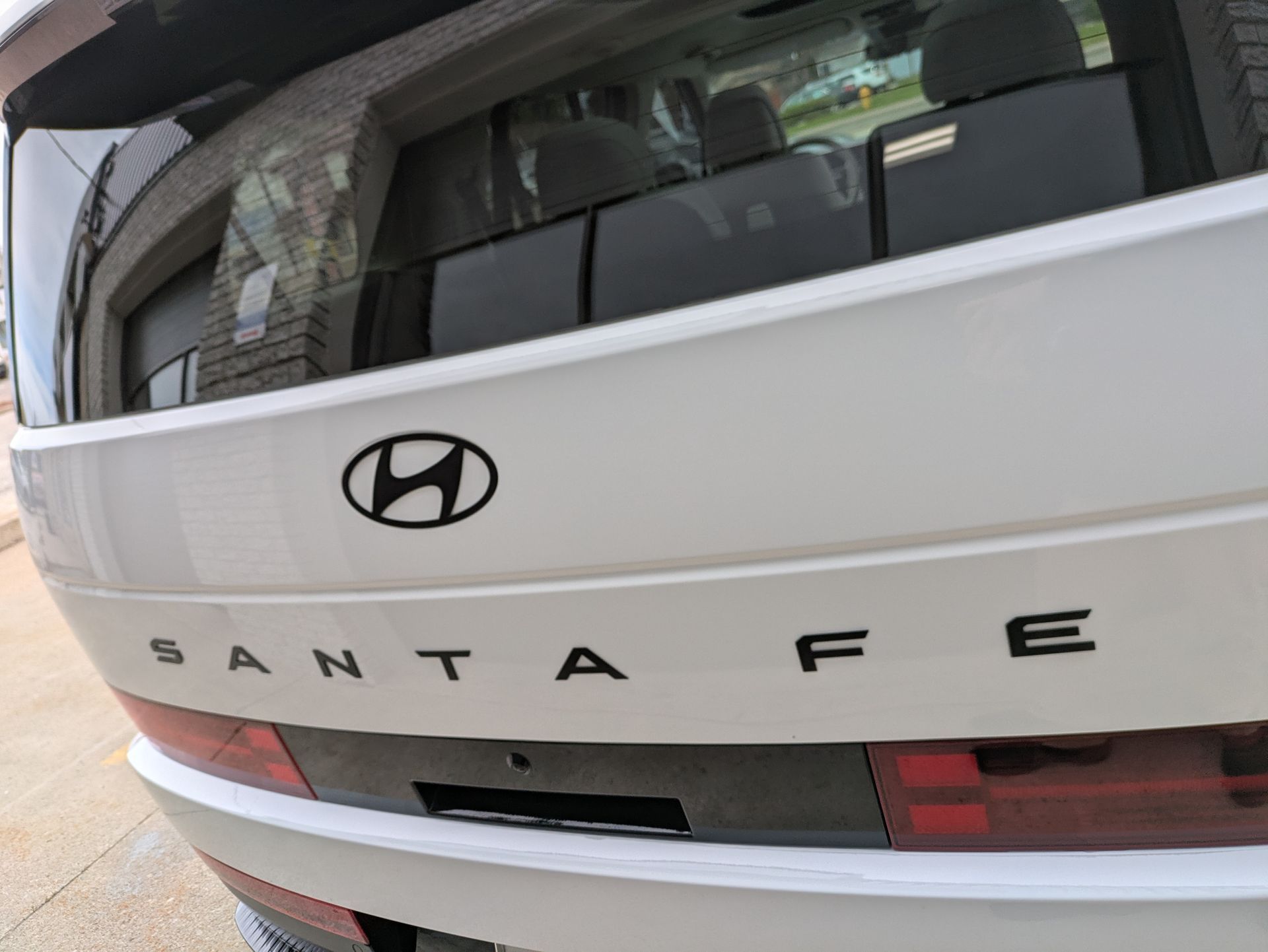 A white hyundai santa fe is parked on the side of the road
