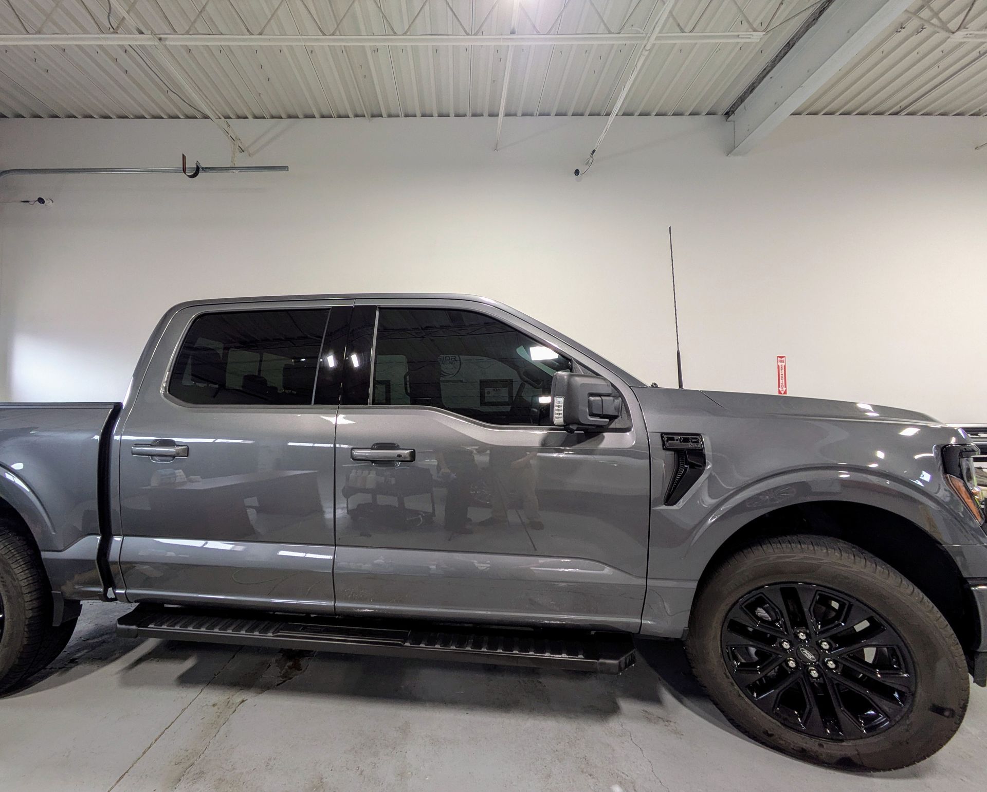 Gray pickup truck parked indoors in a garage, side view.