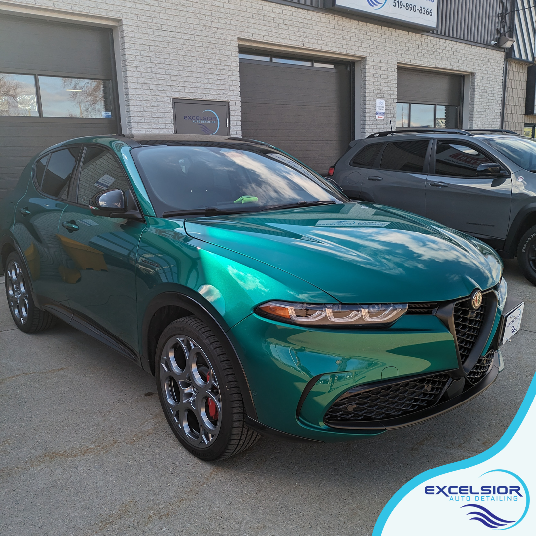A green car is parked in front of a building.