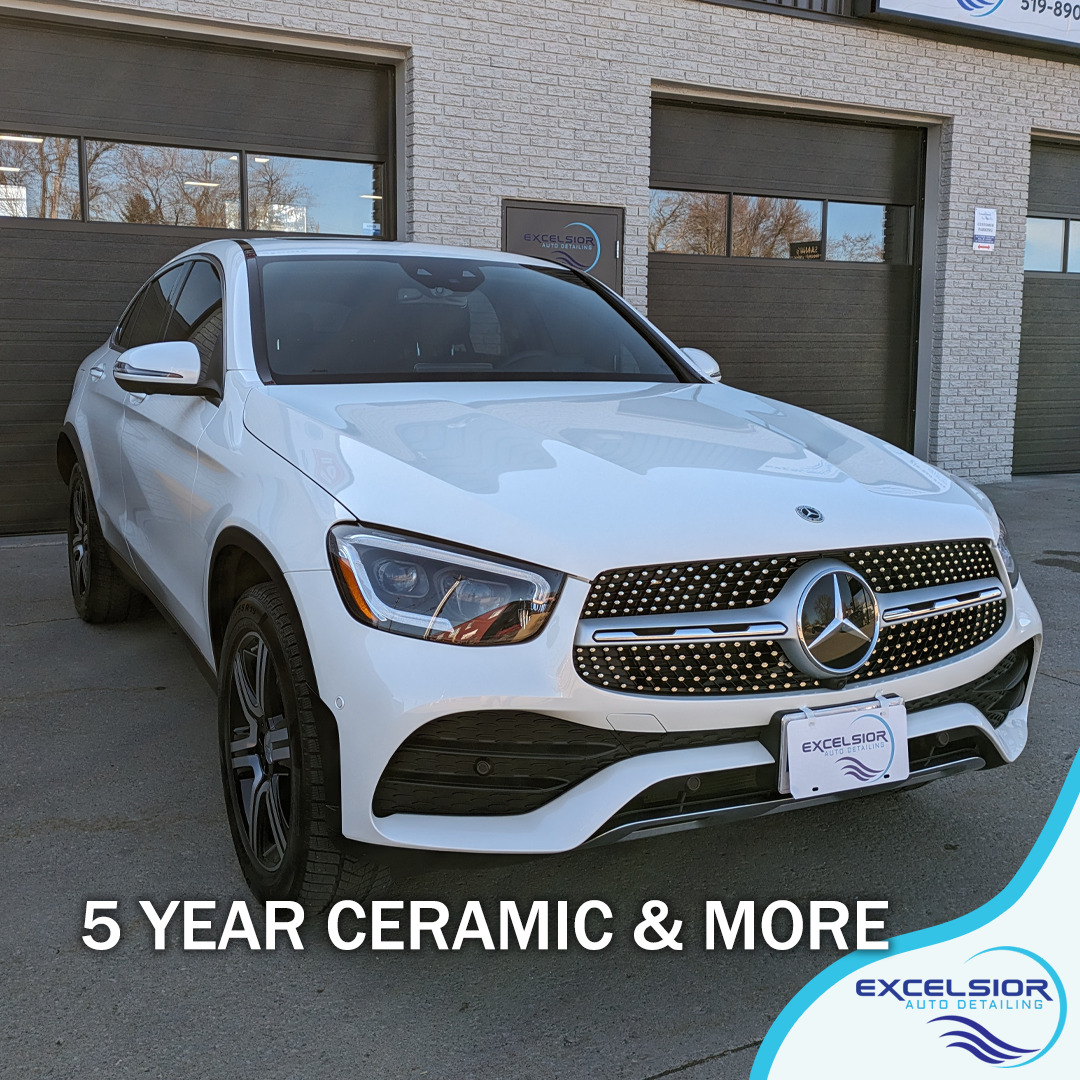 A white mercedes benz glc is parked in front of a garage.