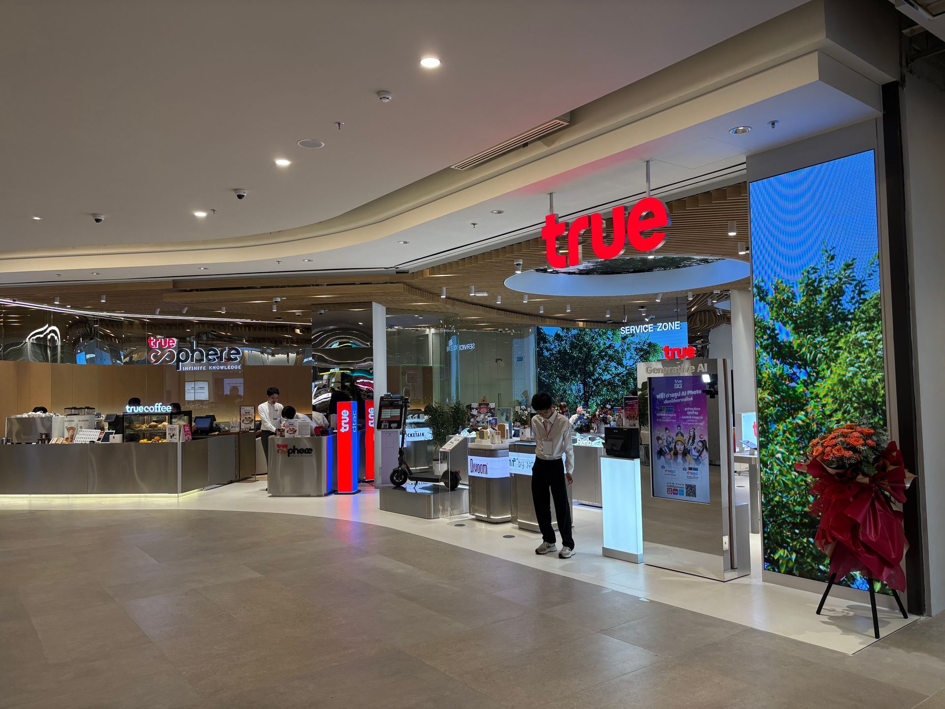 Mall entrance with a red “true” sign, glass storefront, and a person standing by the doorway