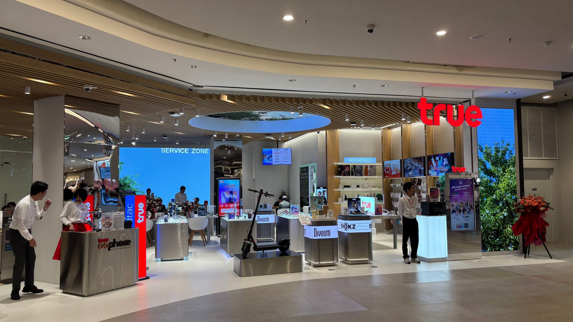 Bright mobile phone store interior with display counters, screens, customers, and a red “true” sign