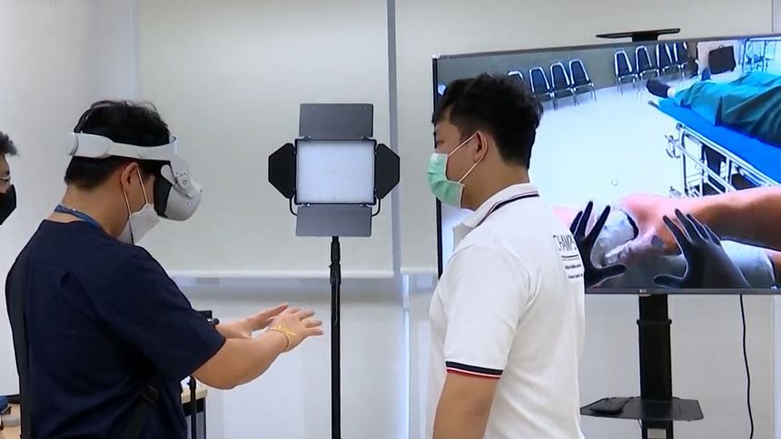 Two people in a tech lab wearing headsets, one gesturing while facing a large display.
