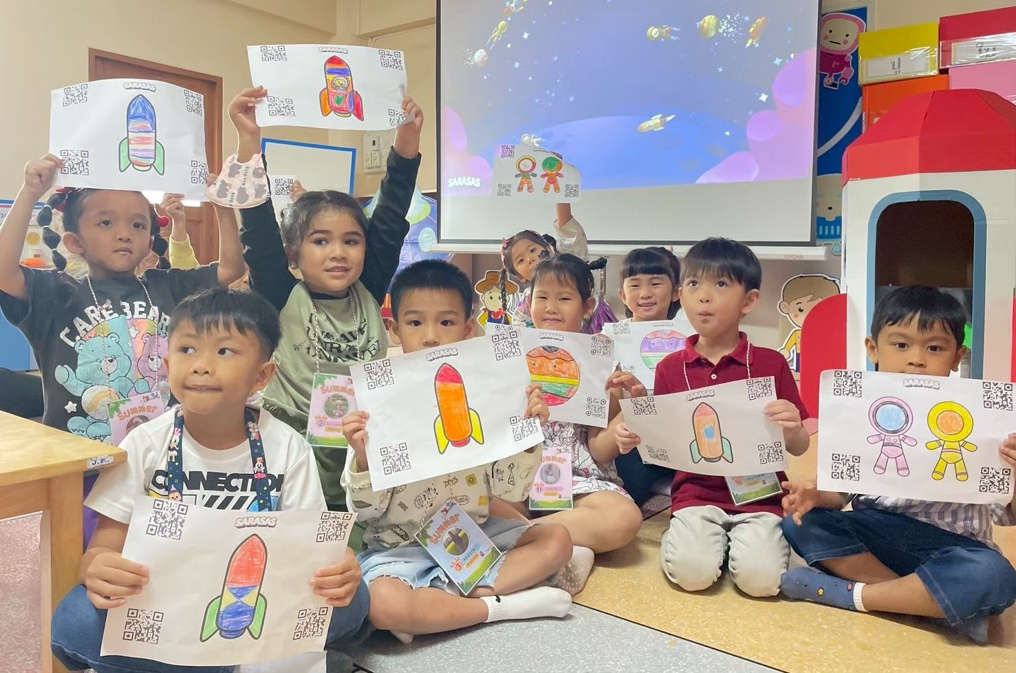 Children in a classroom holding up colorful drawings during an art activity