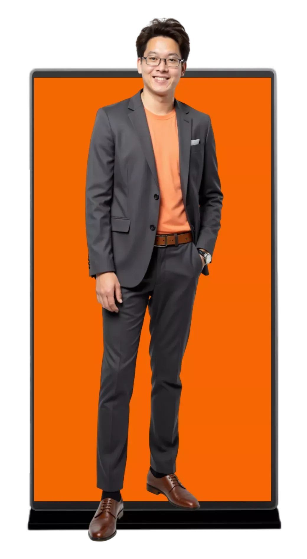 Full-body portrait of a smiling man in a dark suit and orange shirt standing before an orange backdrop.
